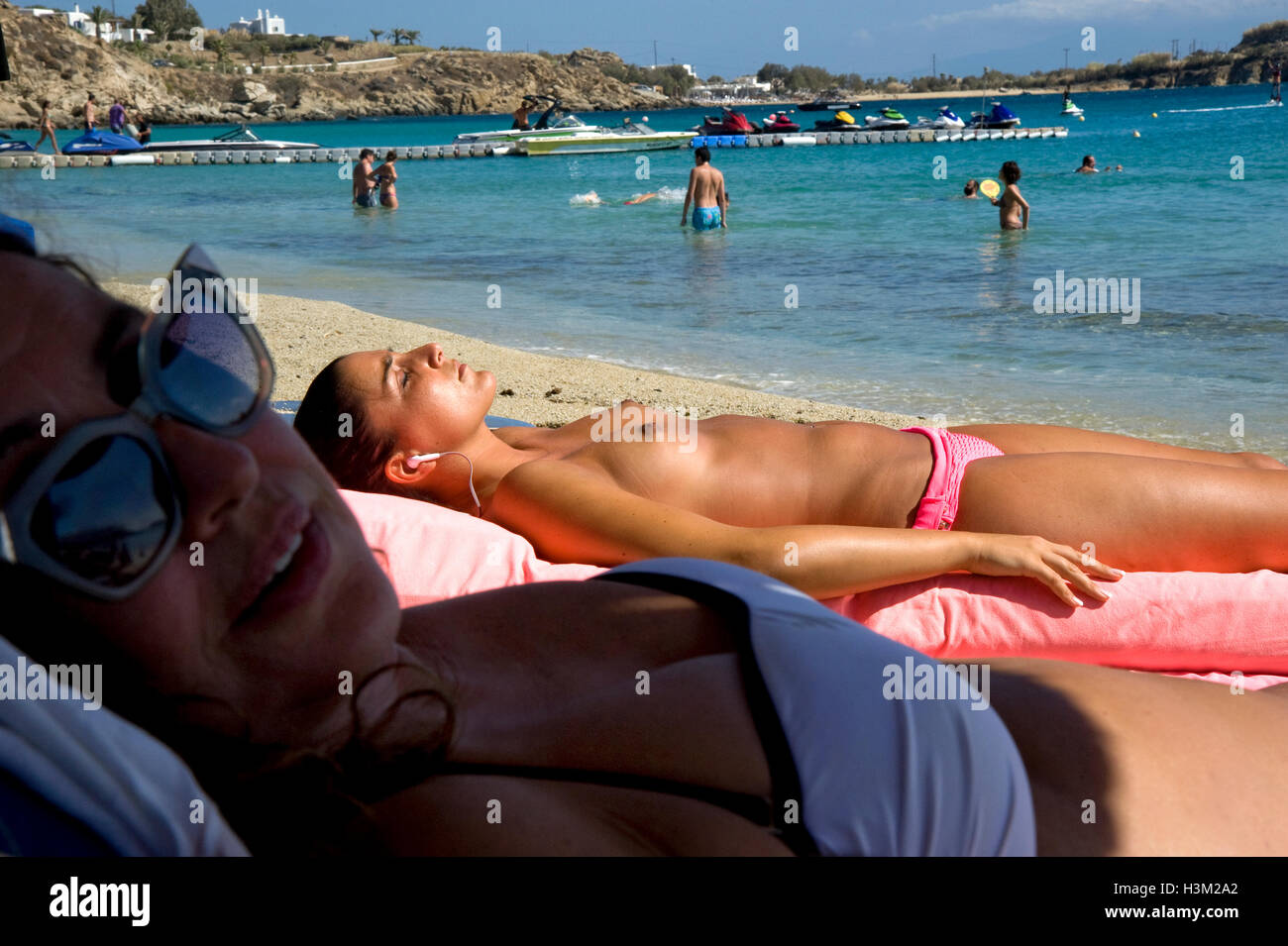 Frau Sonnenbaden oben ohne am Strand auf der Insel Mykonos in Griechenland ...