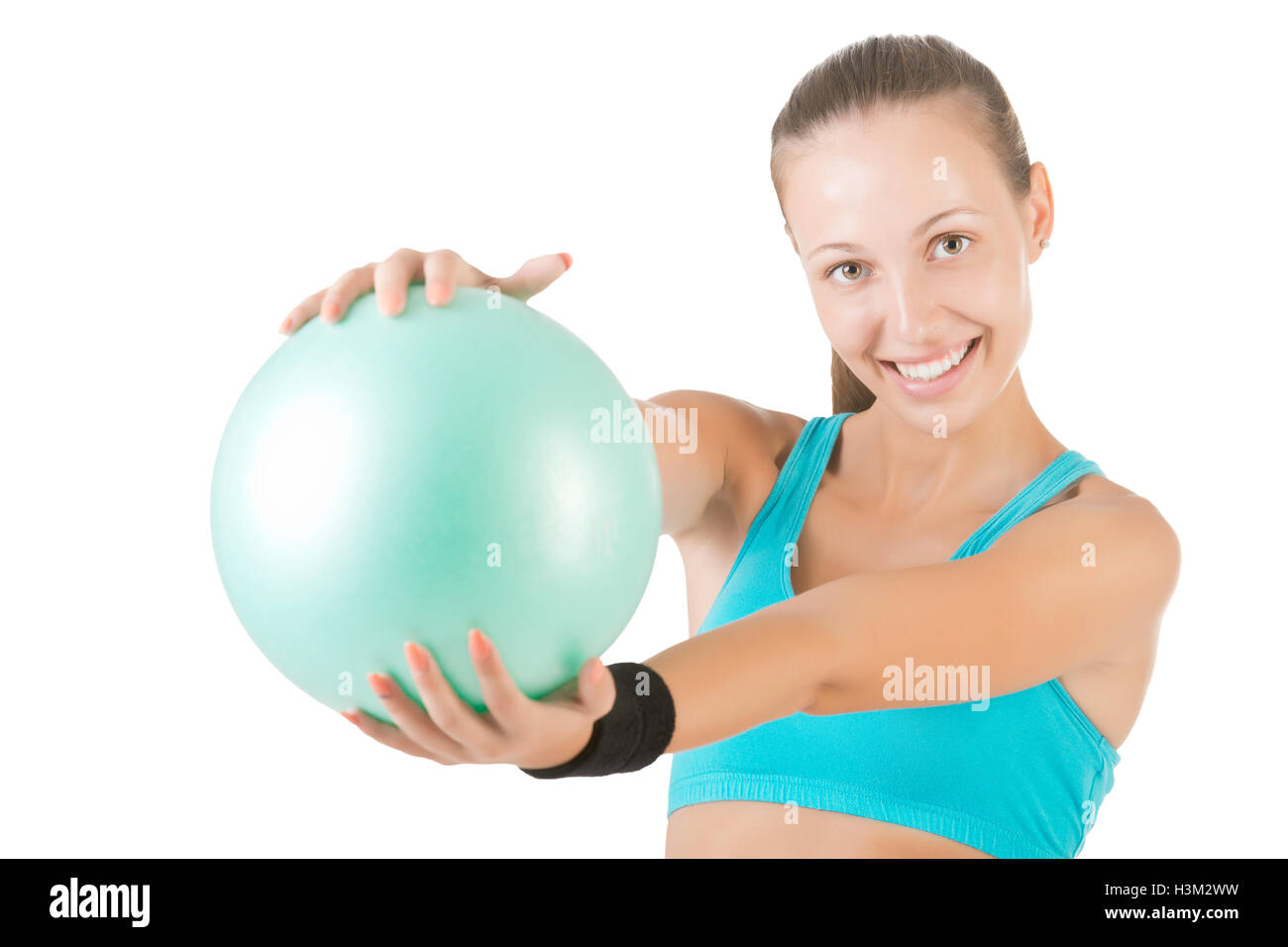 Fit Frau stehen und halten einen Pilates Ball, isoliert in weiß Stockfoto
