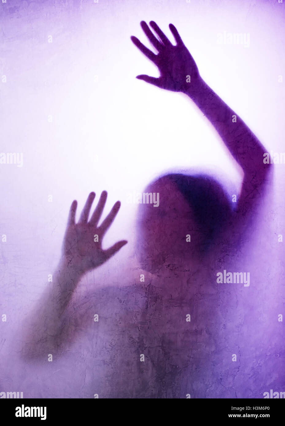 Eingeschlossene Frau Konzept mit Rückseite beleuchteten Silhouette der Hände hinter Mattglas, nützlich als anschauliches Bild für den Menschenhandel, Stockfoto