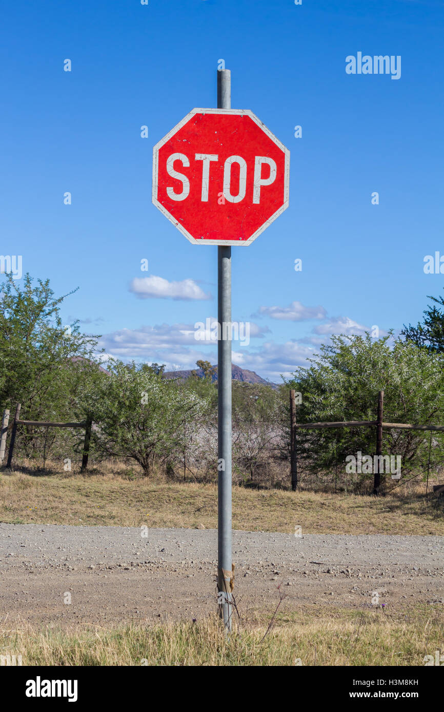 Misshandelte und Peeling alte Stop-Schild neben ländliche unbefestigte Straße Stockfoto