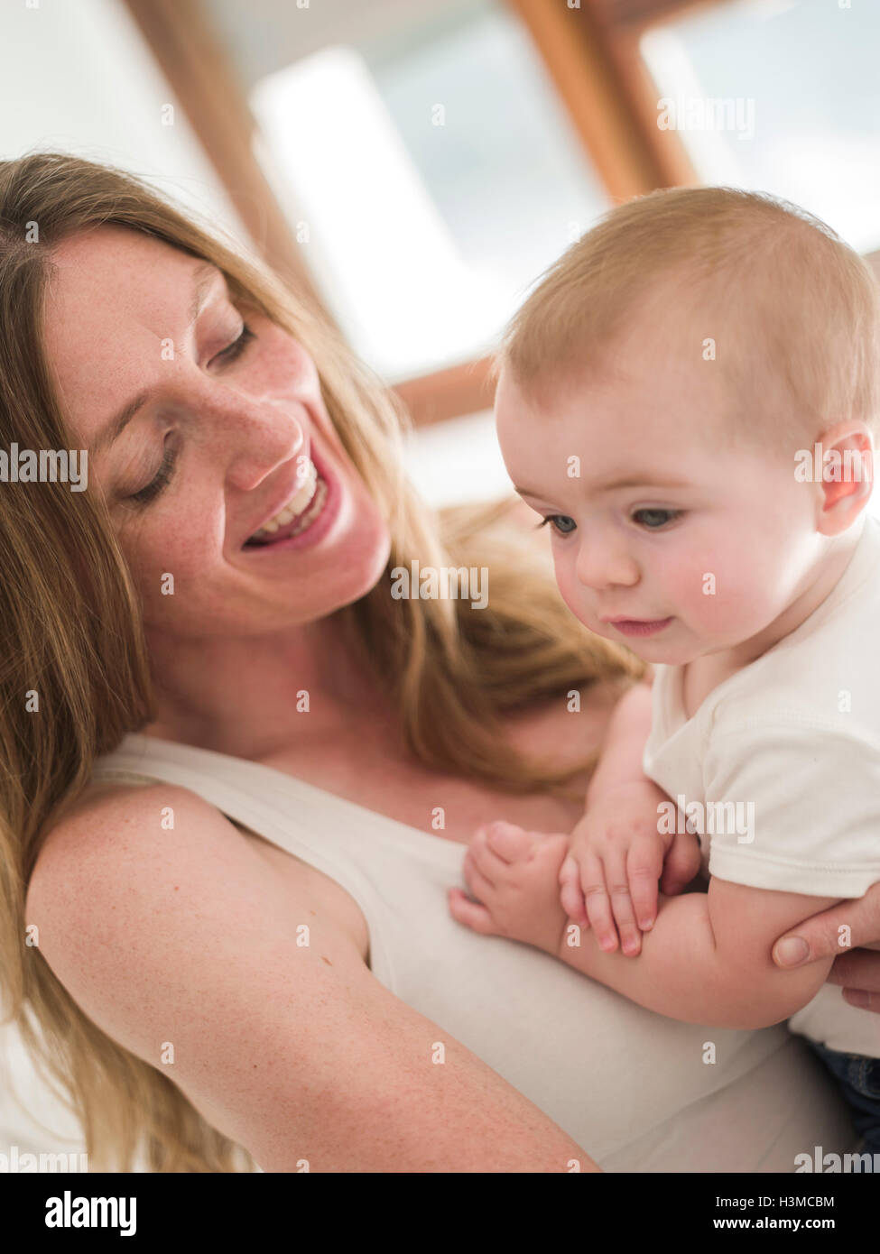 Blick auf lächelnde Mutter hält Babymädchen beschnitten Stockfoto