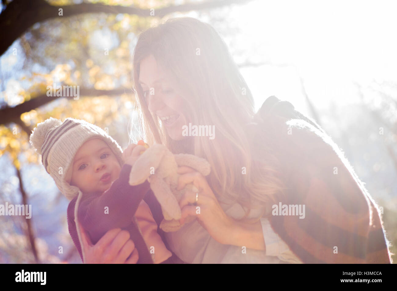 Mutter und Baby mit Kuscheltier im Wald Stockfoto