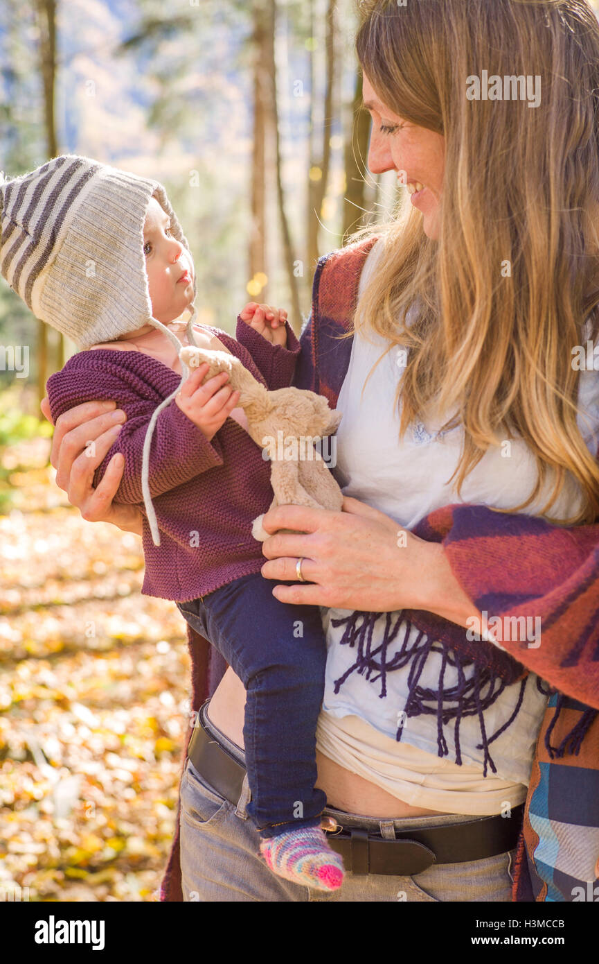 Mutter und Baby mit Kuscheltier im Wald Stockfoto
