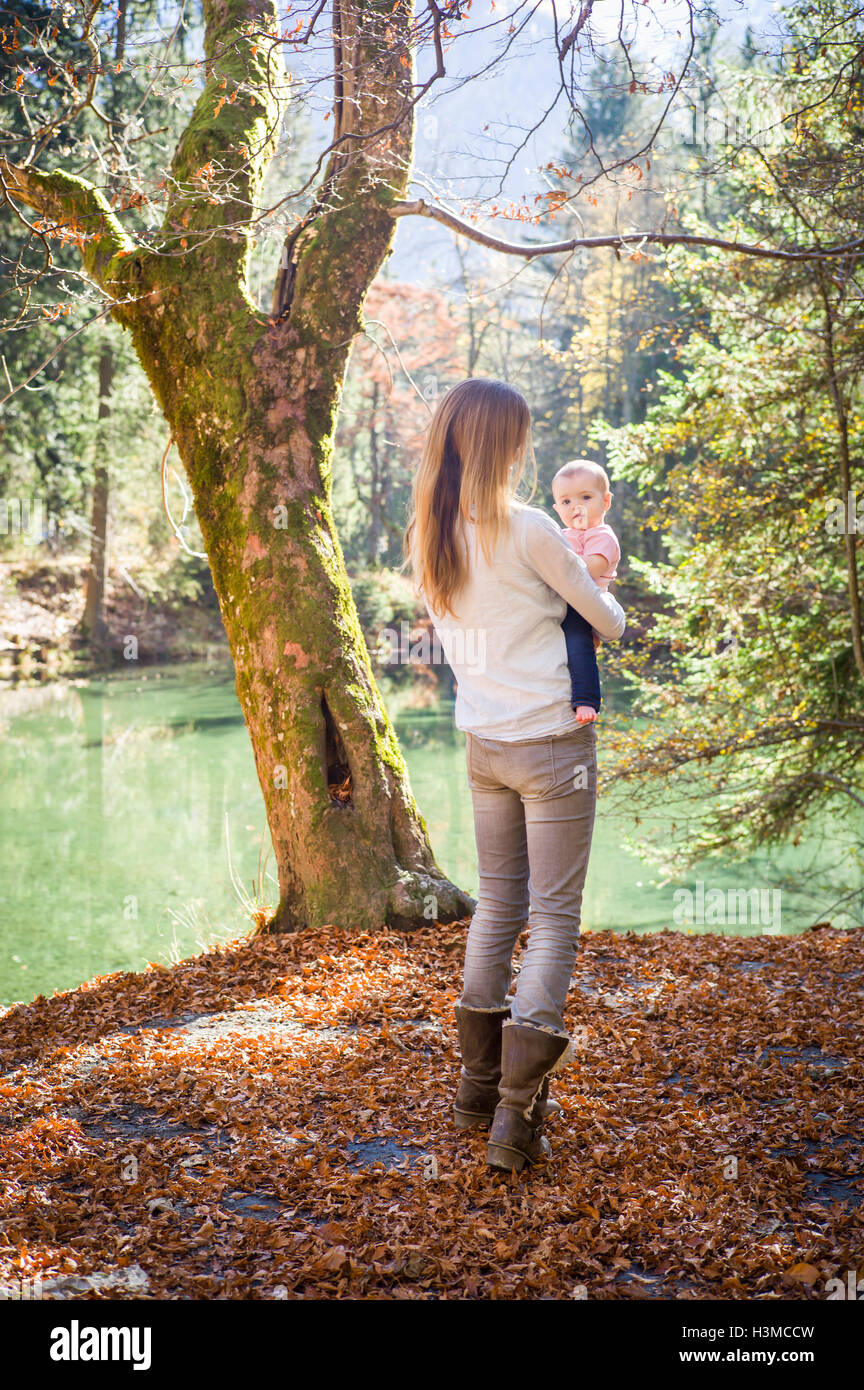 Rückansicht des Mutter und Baby Mädchen im Wald von Wasser Stockfoto