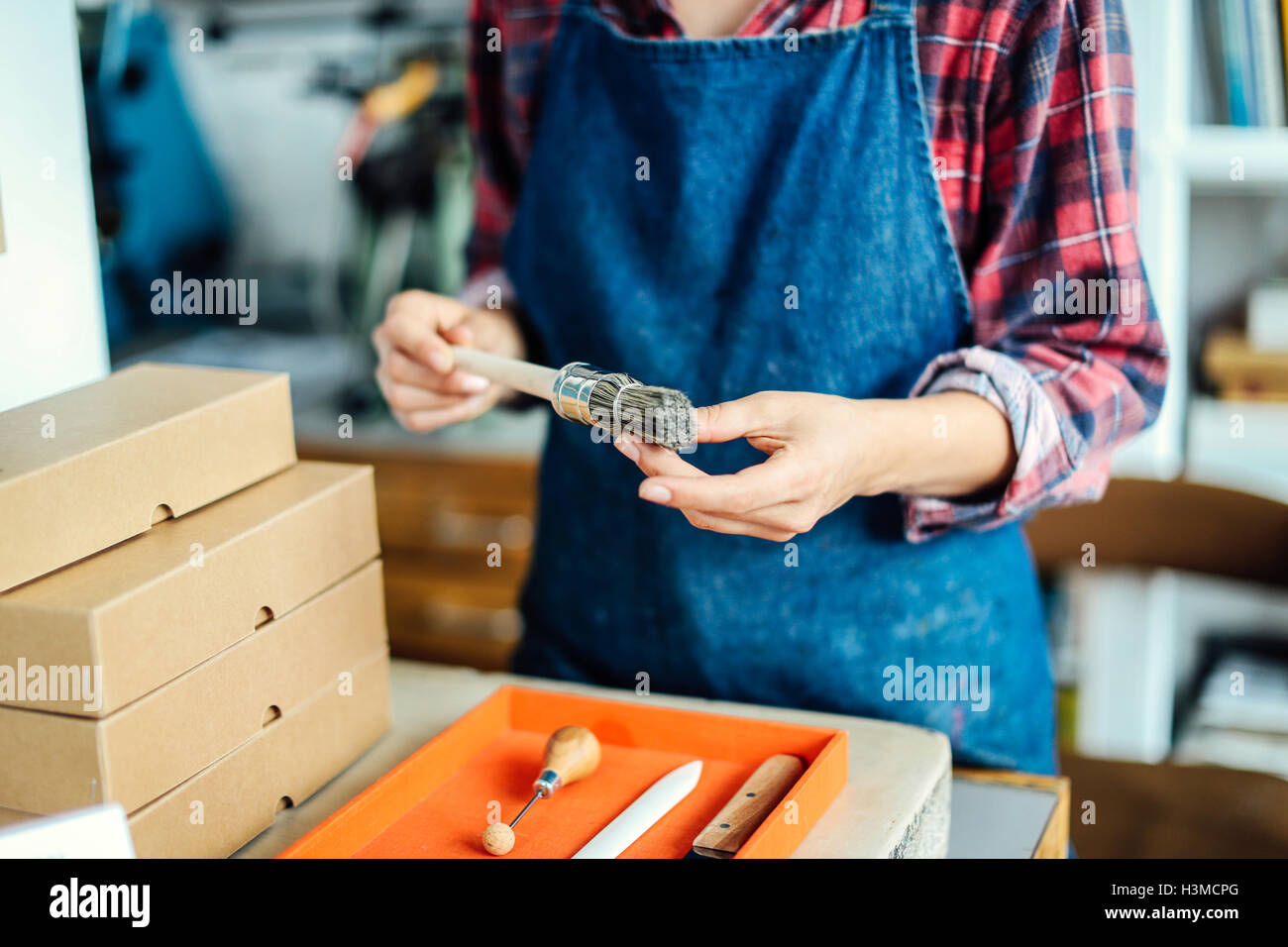 Details von Händen mit Pinsel im Buch-Kunst-studio Stockfoto