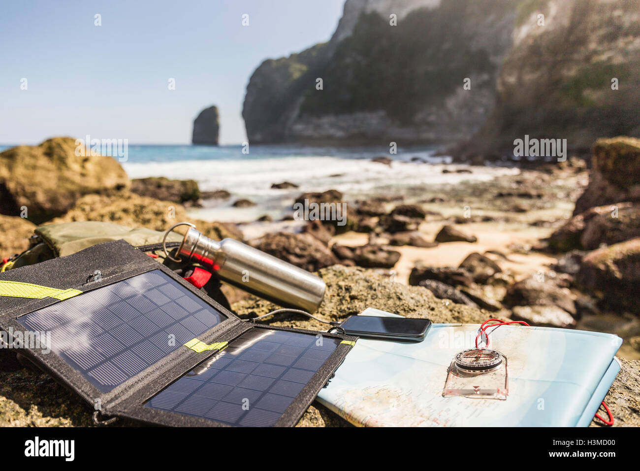 Solar-Ladegerät und Smartphone am Strand, South Coast, Nusa Penida, Indonesien Stockfoto