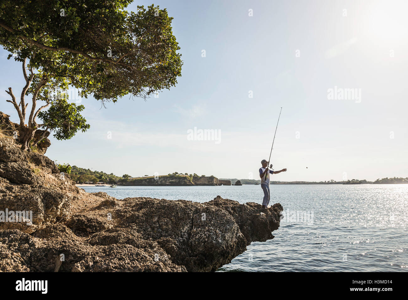 Mann Angeln vom Felsen, Pink Beach, Lombok, Indonesien Stockfoto