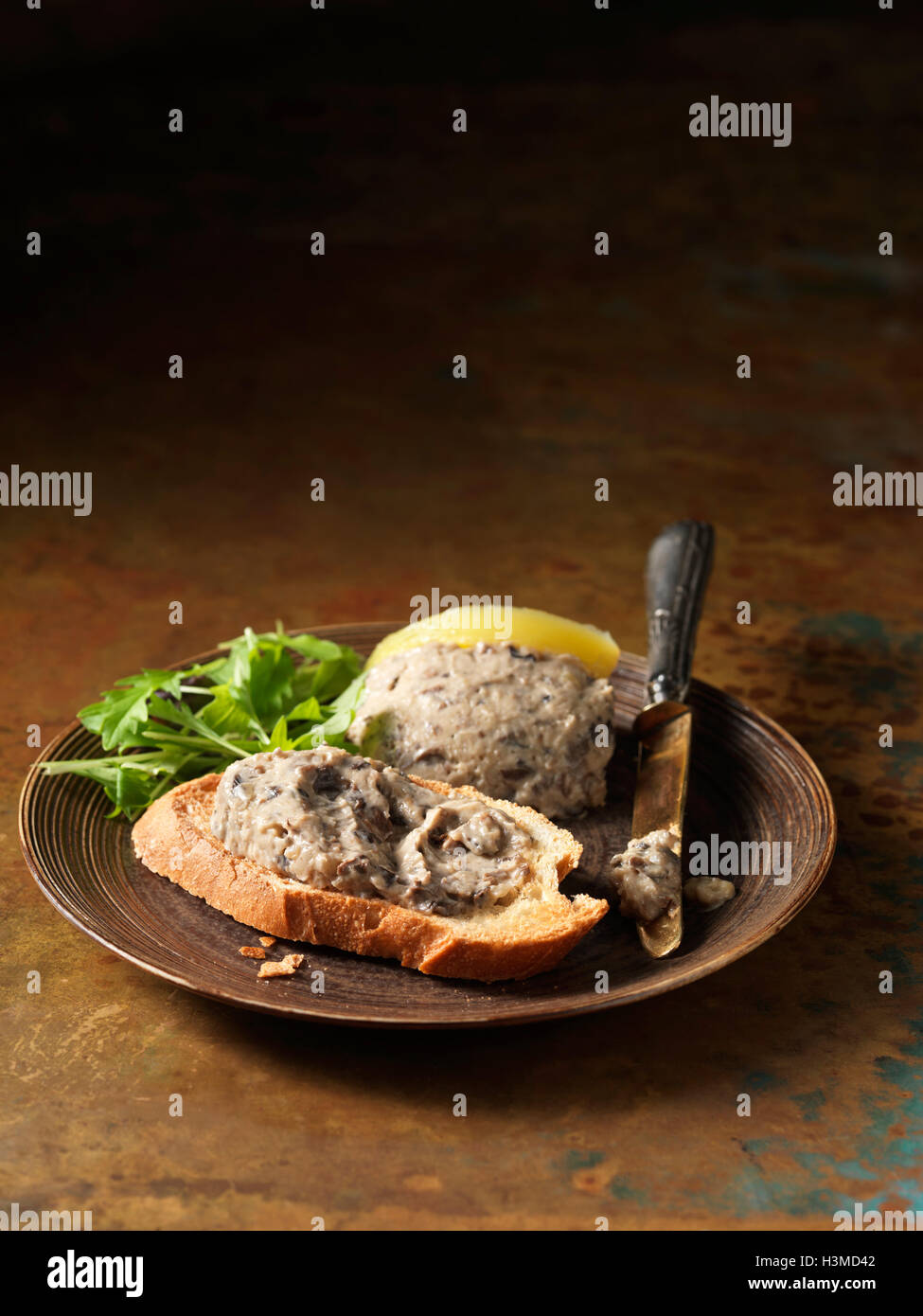 Ofen gerösteten wild Pilz Pastete auf knusprigem Brot und Rucola Stockfoto
