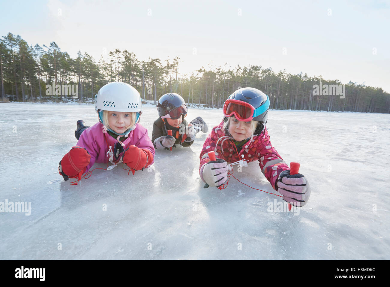 Porträt von Mädchen und jungen kriechen auf zugefrorenen See, Hotels, Schweden Stockfoto