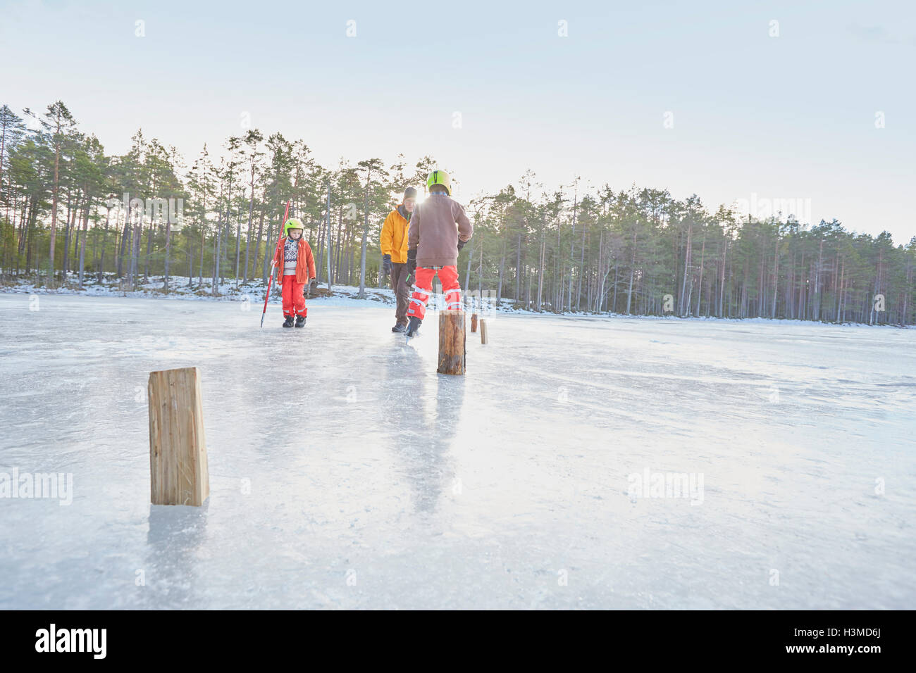 Älteren Menschen und jungen üben Eislaufen Slalom am zugefrorenen See, Hotels, Schweden Stockfoto