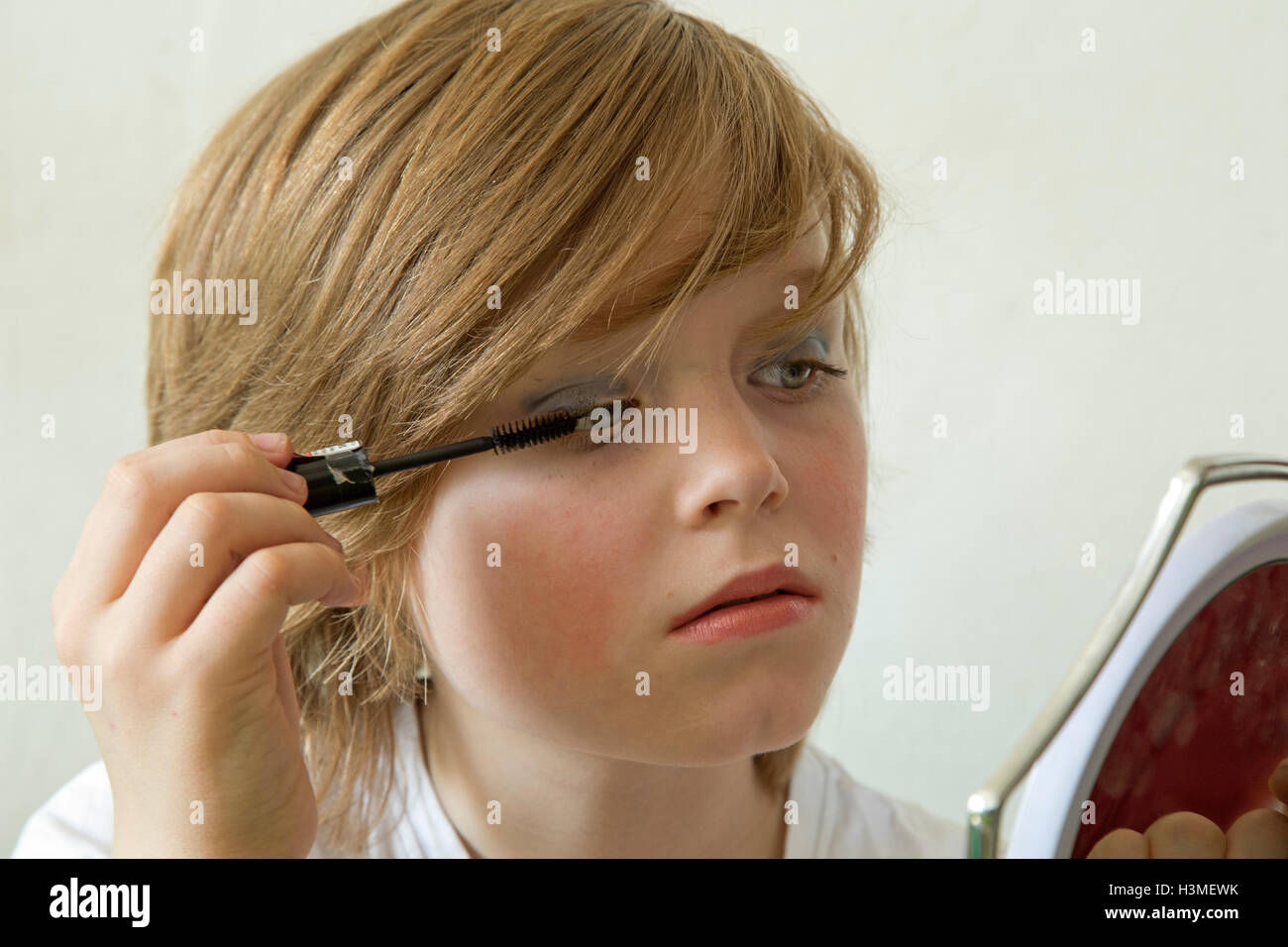 kleiner Junge putting make-up auf vorgibt, ein Mädchen zu sein Stockfoto