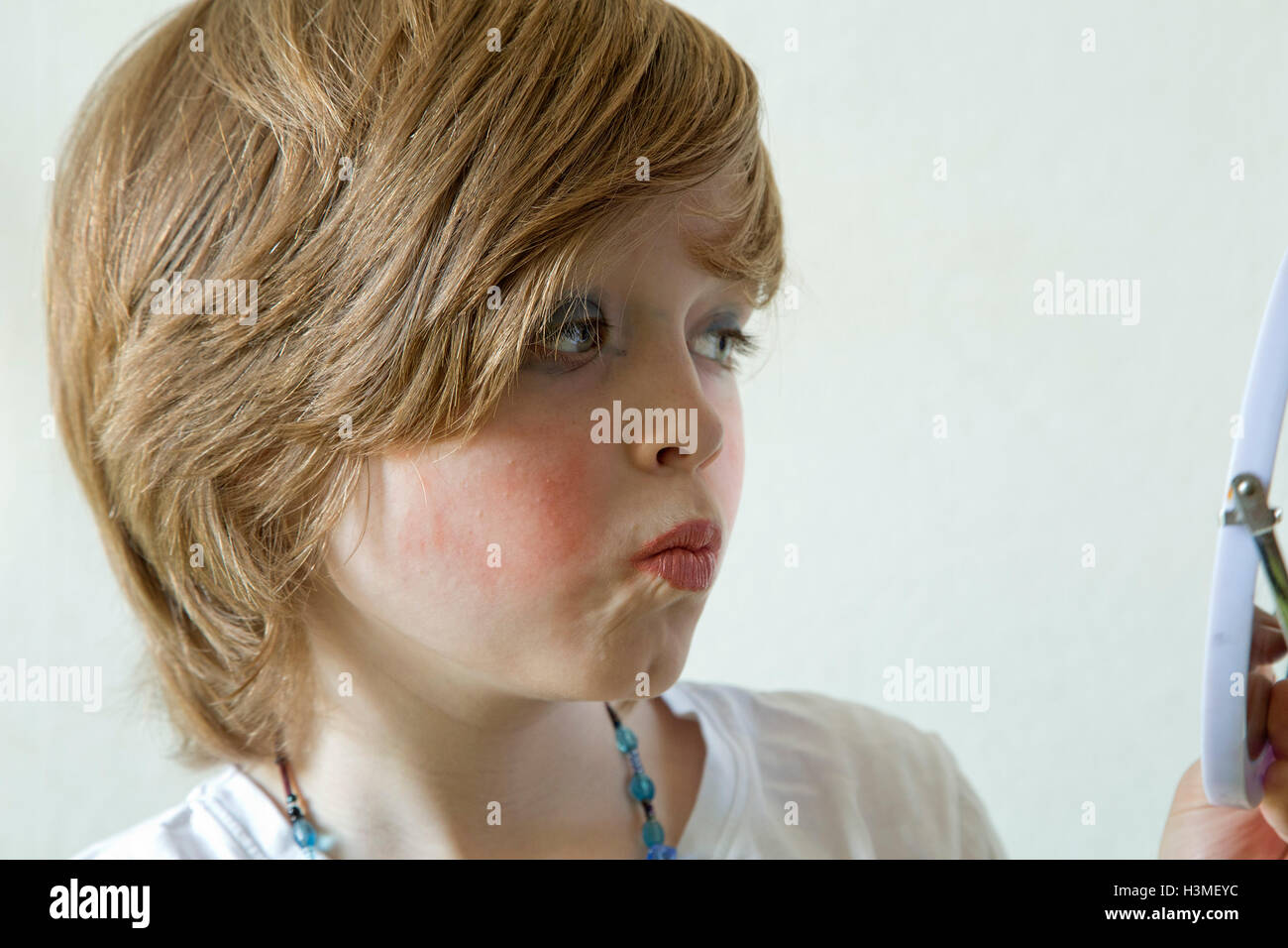 kleiner Junge putting make-up auf vorgibt, ein Mädchen zu sein Stockfoto