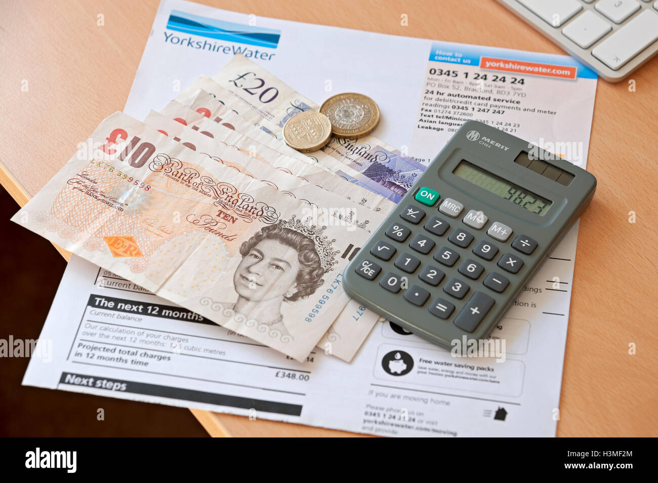Nahaufnahme der Hauswasserrechnung Haushaltsrechnungen Rechner und Bargeldzahlung England UK Vereinigtes Königreich GB Großbritannien Stockfoto