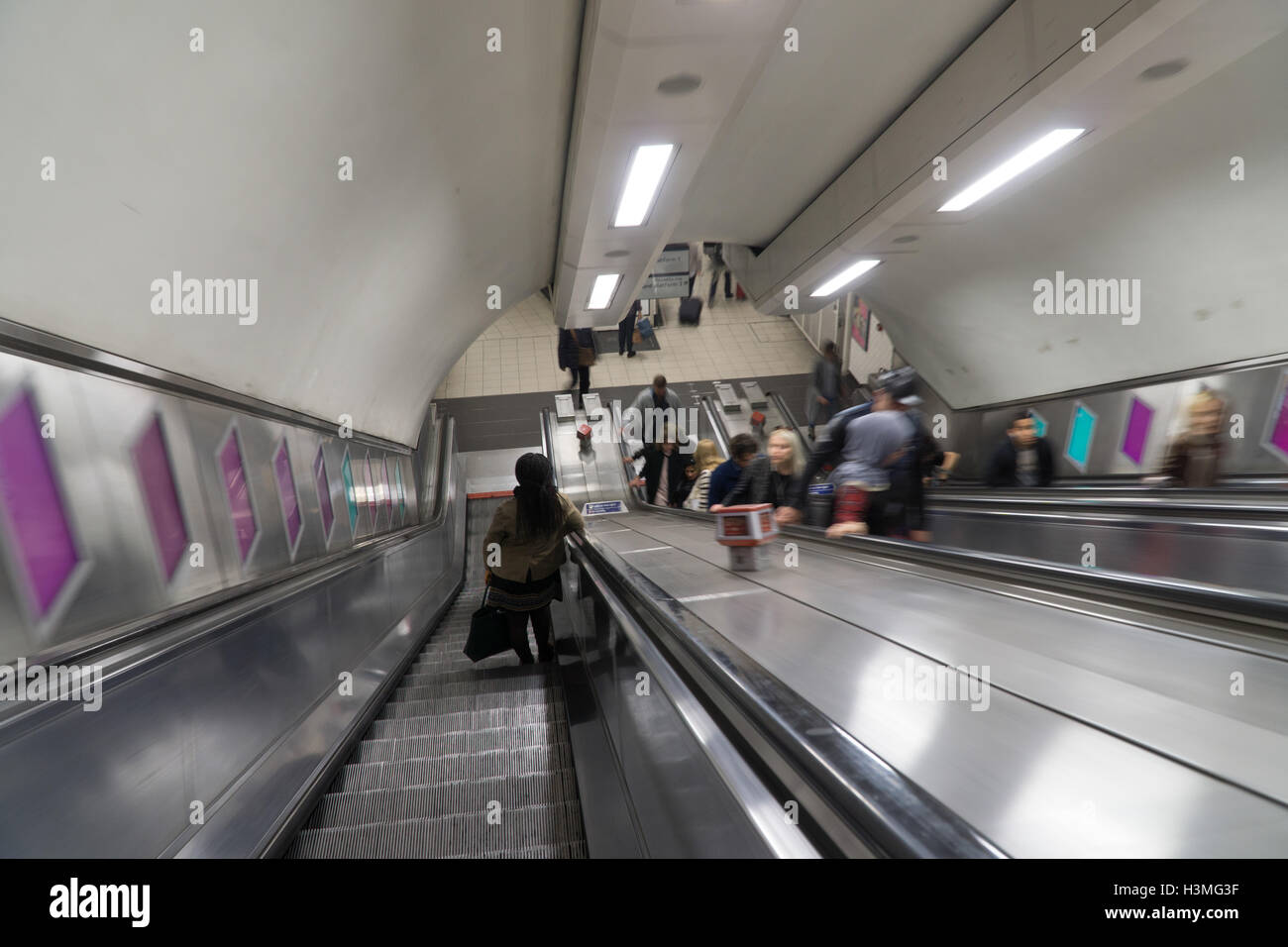 Langsame Kamera Geschwindigkeit übertreiben Spiegelschlag auf einer London unterirdische Rolltreppe. Stockfoto