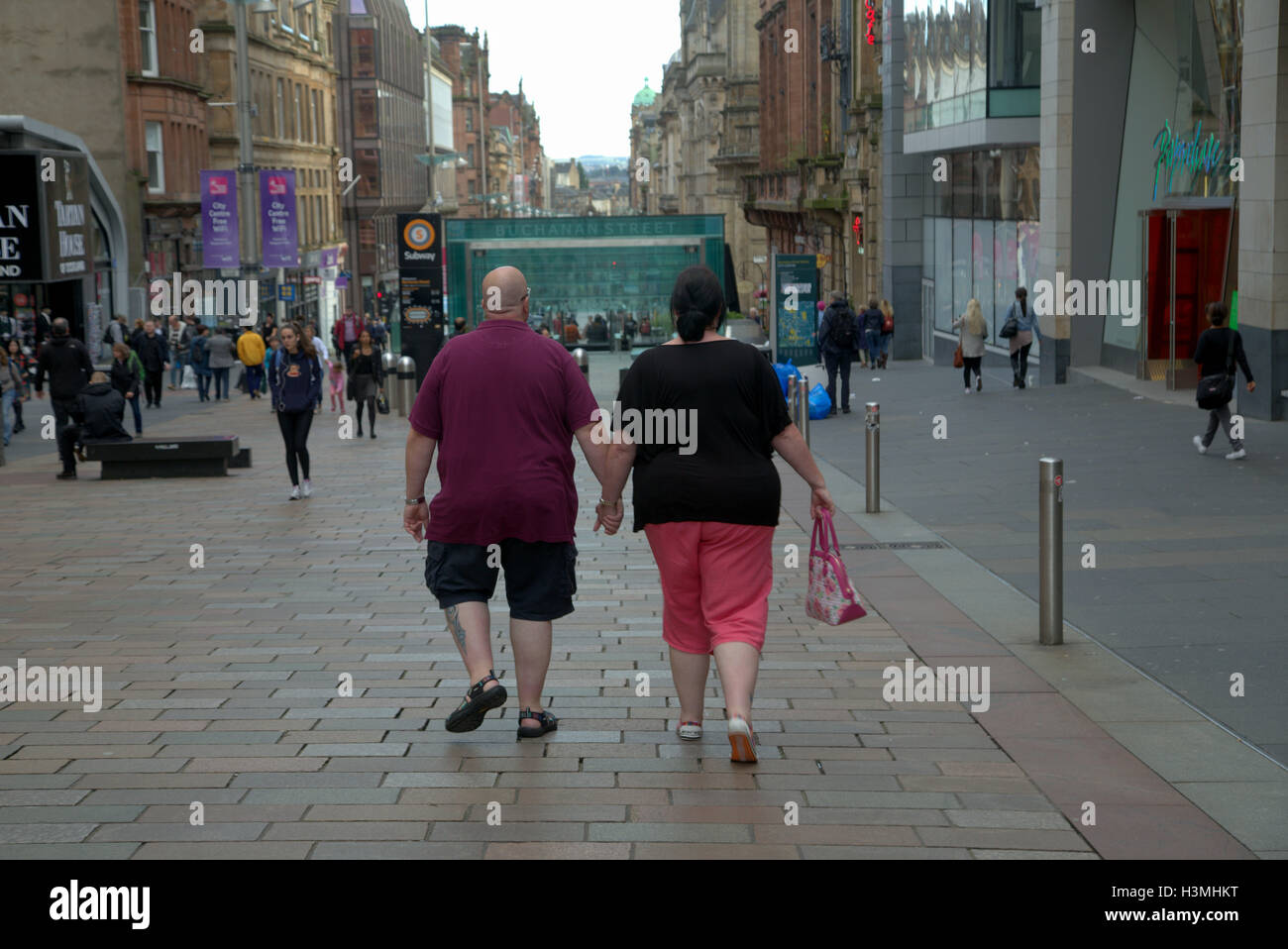 Glasgow Straßenszenen Übergewicht paar Hand in Hand an der Buchanan street Stockfoto