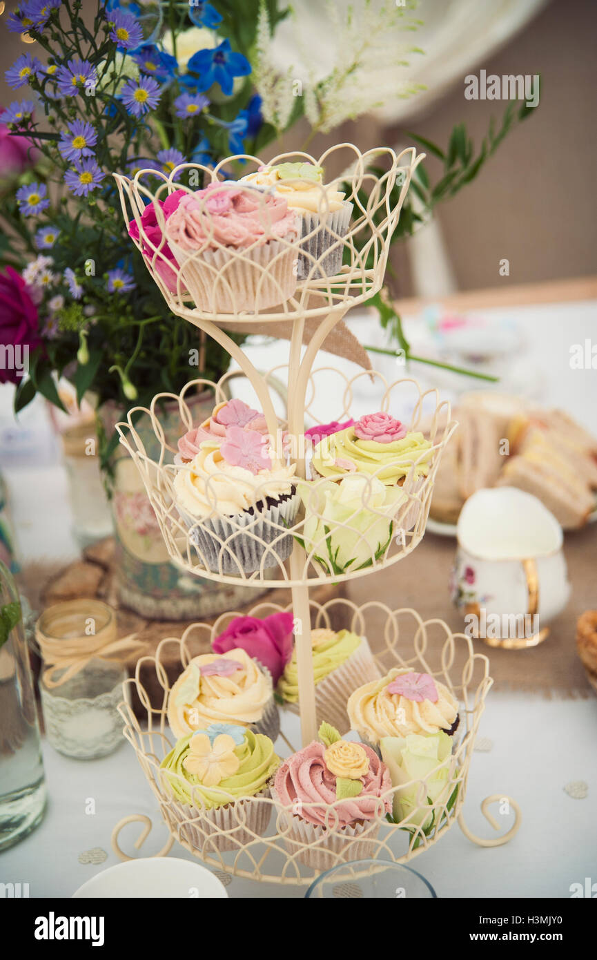 Ziemlich bunte Cupcakes auf eine Multi-tiered Kuchenplatte Stockfoto