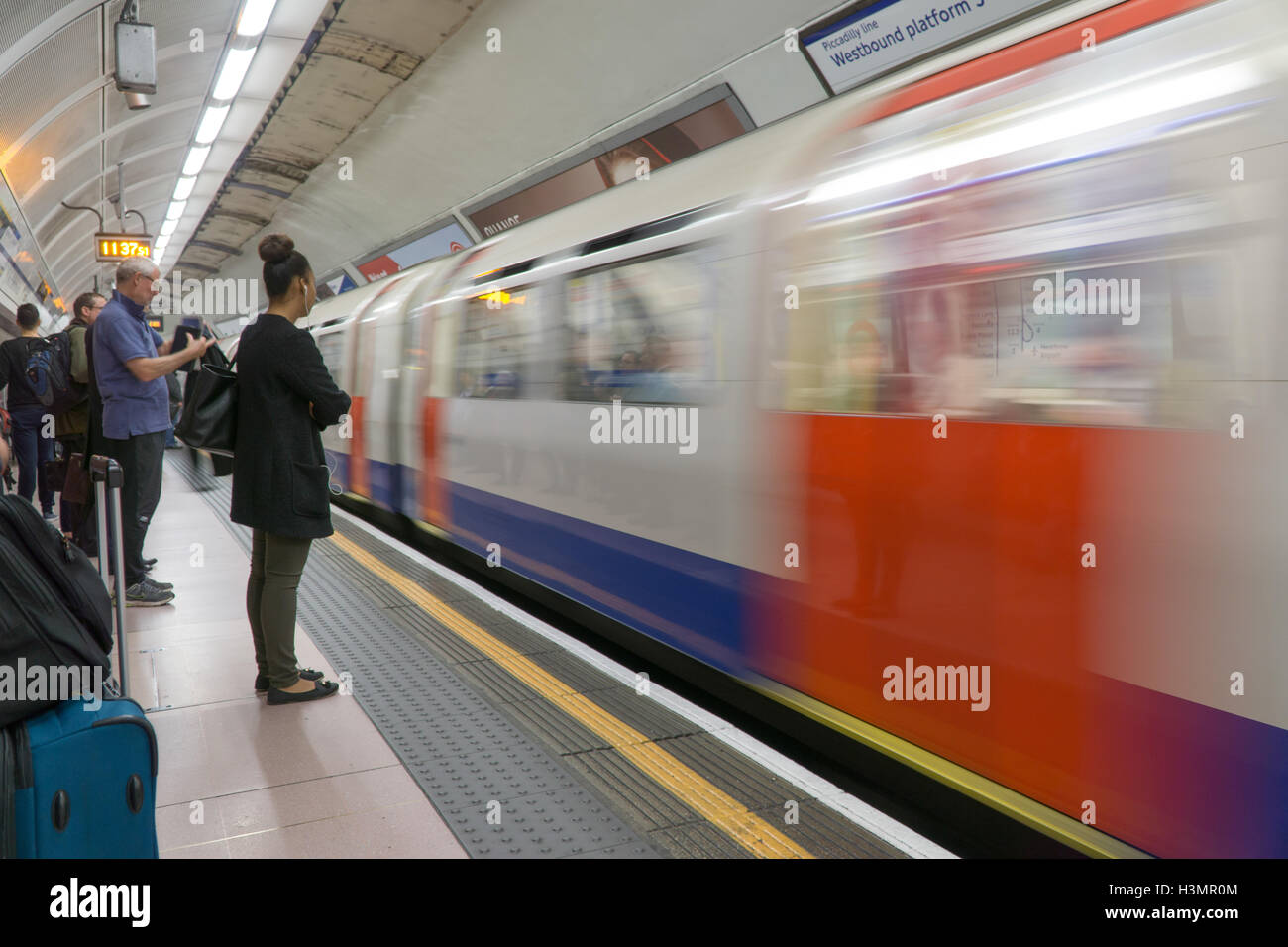 Trainieren Sie Pendler auf die Londoner U-Bahn, warten auf einen Zug zu stoppen. Stockfoto