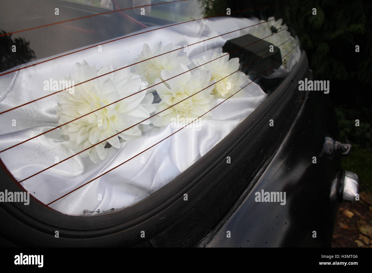 Weiße Hochzeitsblumen im Taxi-Fenster Stockfoto