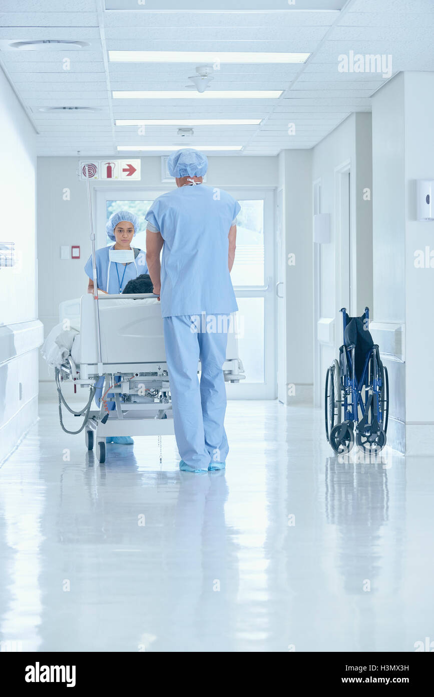 Männlichen und weiblichen Krankenschwestern Krankenhausflur Bett drücken Stockfoto
