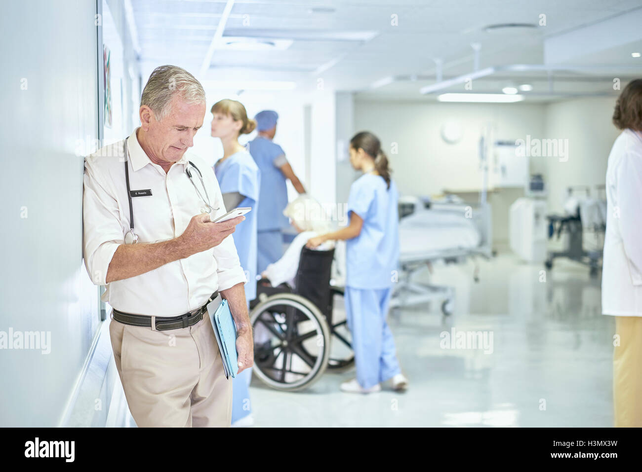 Leitender Arzt lesen Smartphone Nachricht in Spitalabteilung Stockfoto