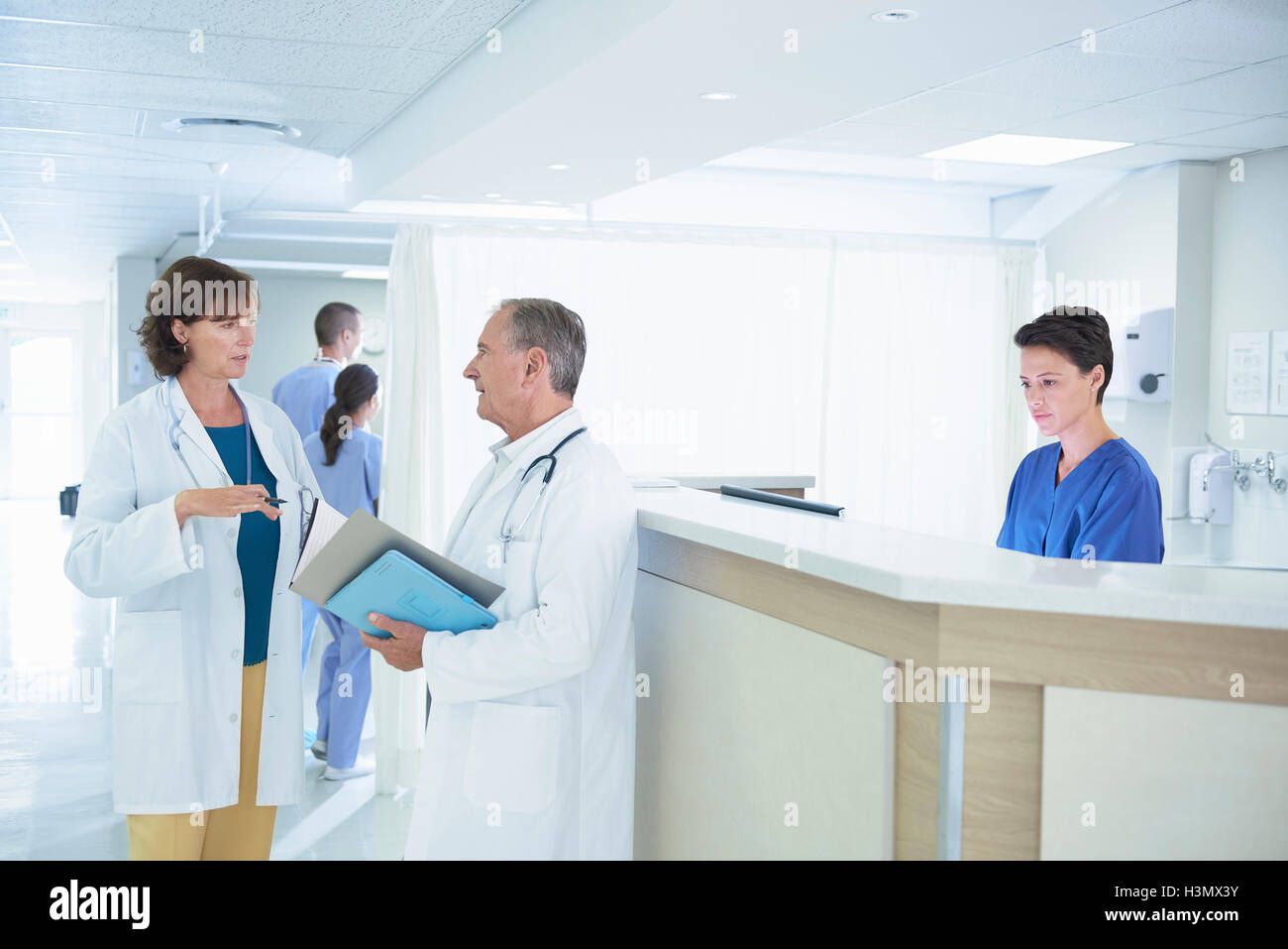 Männliche und weibliche Ärzte medizinische Hinweise am Krankenhaus Krankenschwestern Bahnhof diskutieren Stockfoto