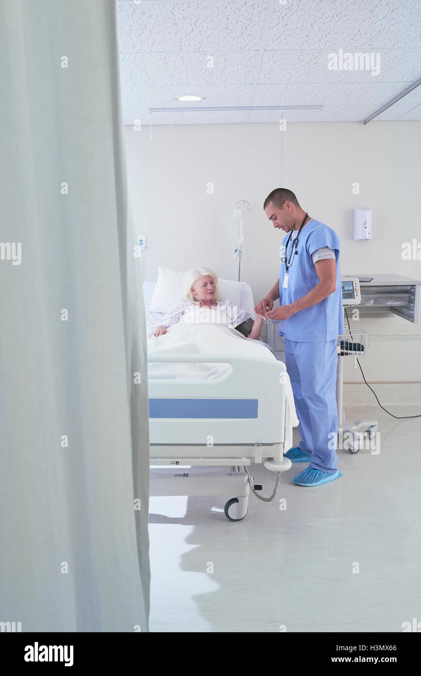 Krankenpfleger mit Blut des Manometers auf ältere Patientin im Krankenhausbett Stockfoto