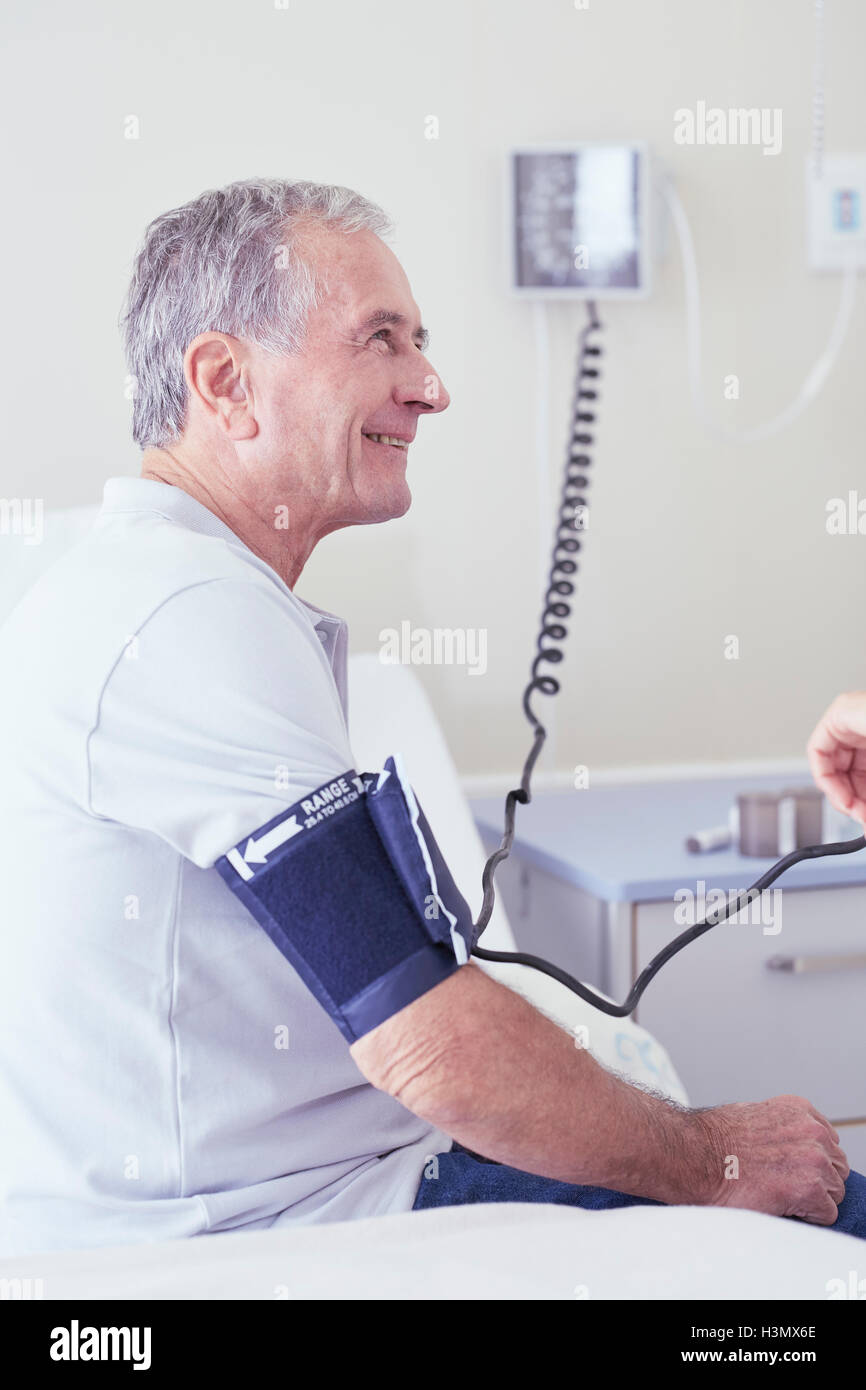 Senior männlicher Patient mit Blutdruck vom Arzt Stockfoto