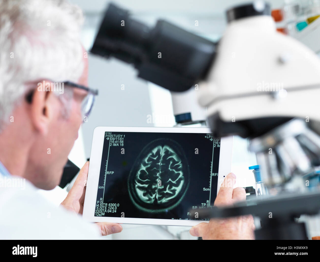 Arzt einen MRI Gehirn-Scan auf digital-Tablette in einem Labor anzeigen Stockfoto