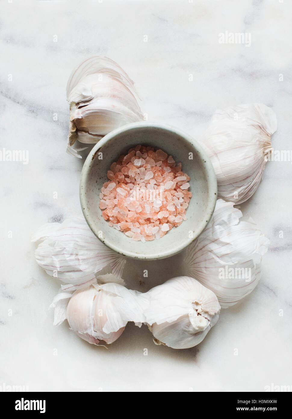 Knoblauch Zwiebeln und rosa Meersalz in Schüssel Stockfoto