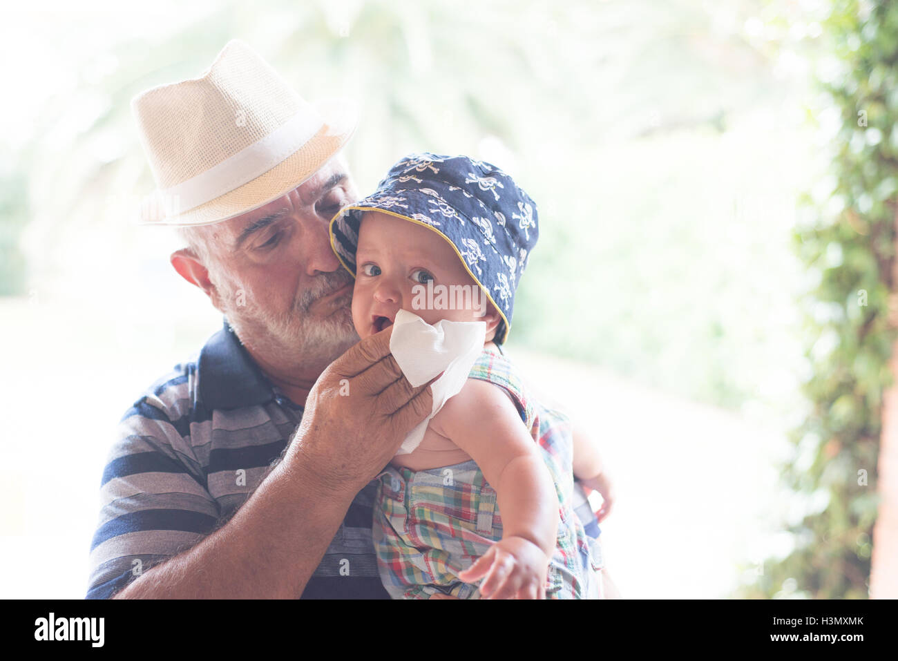 Großvater abwischen Babyjungen Kinn mit Taschentuch Stockfoto