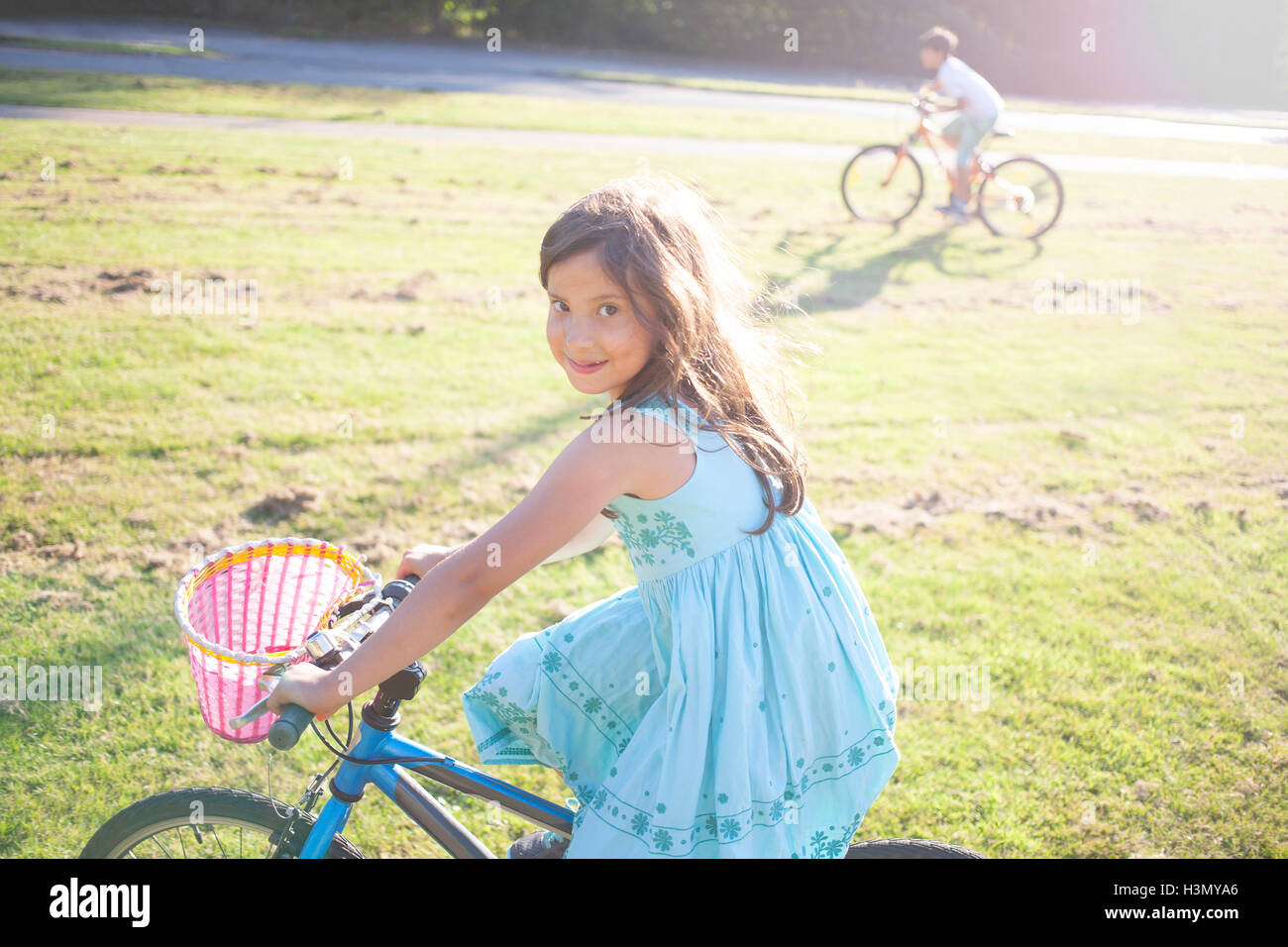 Junges Mädchen und jungen Reiten Fahrrad im Sommersonne Stockfoto
