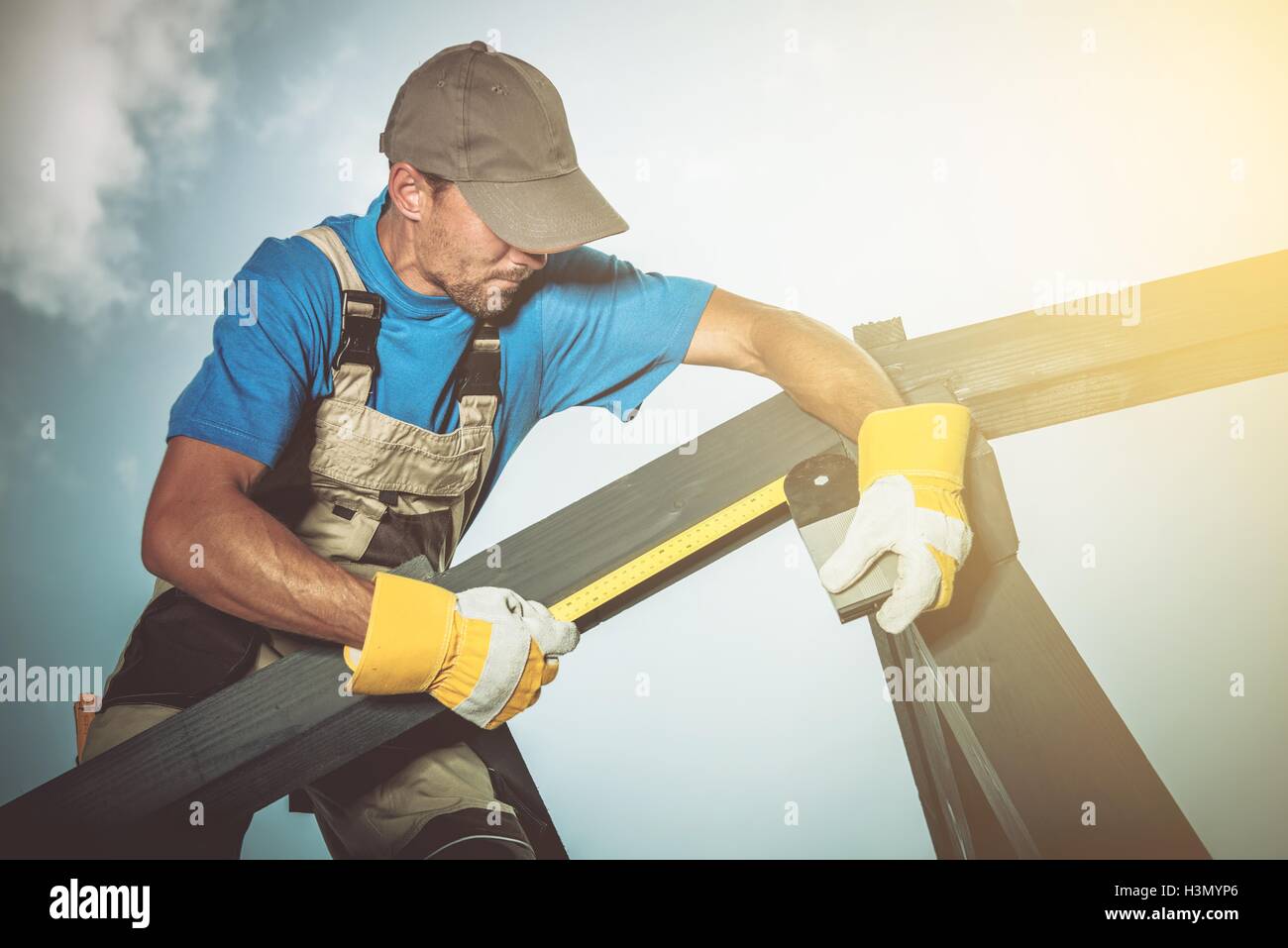 Holzbau-Job. Kaukasische Bauarbeiter Holzelemente zu messen. Stockfoto