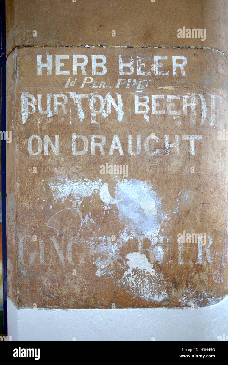 alten verwitterten Pub Ingwer und Burtons Bier unterzeichnen auf rotem Sandstein-Gebäude Stockfoto