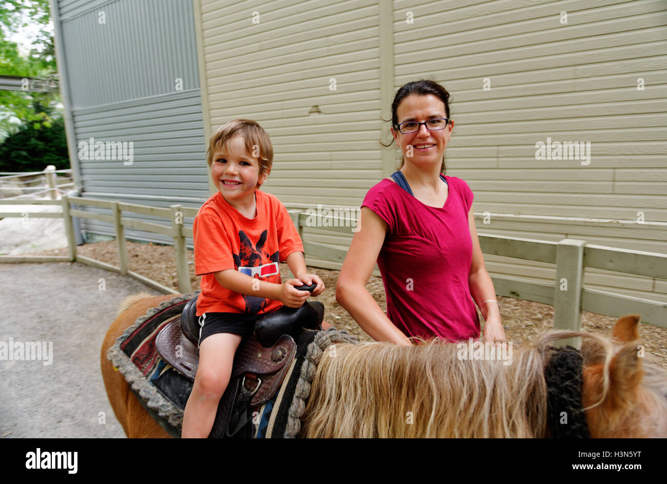 Eine stolze Mutter und ihren vier Jahre alten Sohn auf seine erste Pony-reiten Stockfoto