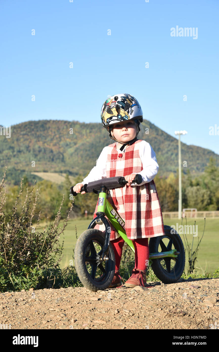 Ein zwei Jahre altes Mädchen, das auf einem Gleichgewicht bike Stockfoto