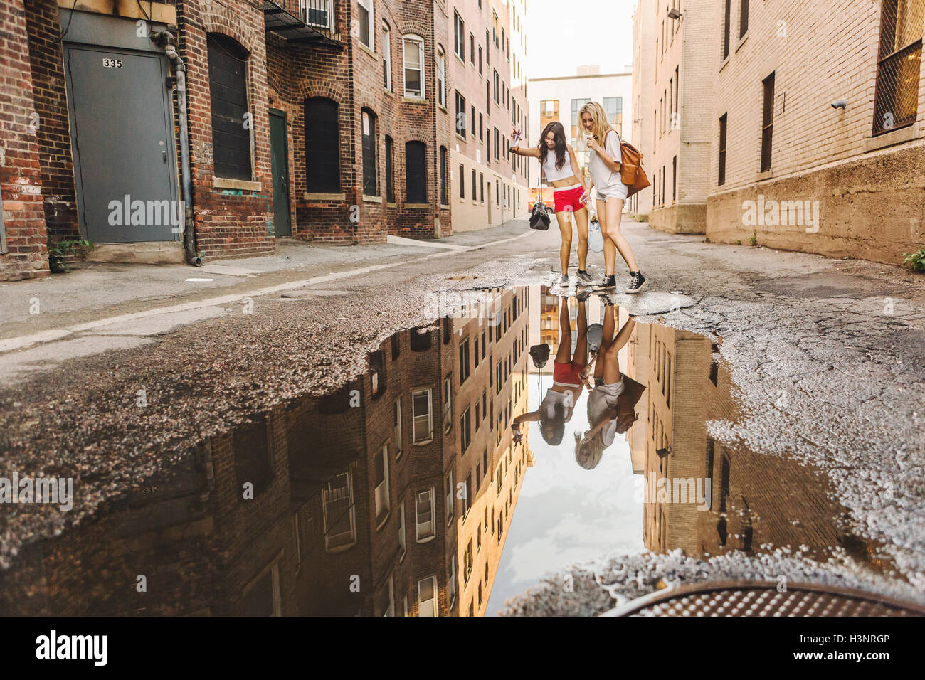 Frauen, die zu Fuß durch Pfütze auf Straße, Boston, MA, USA Stockfoto