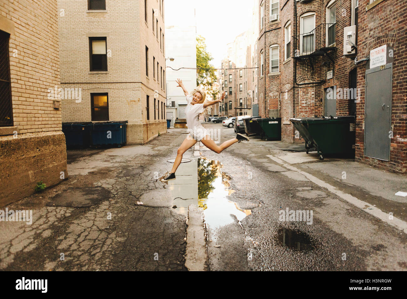 Frau, springen über die Pfütze auf Straße, Boston, MA, USA Stockfoto