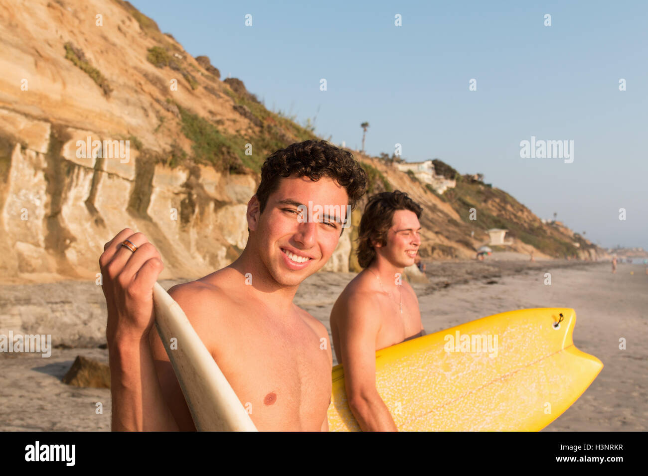 Zwei junge Männer am Strand, hält Surfbretter Stockfoto
