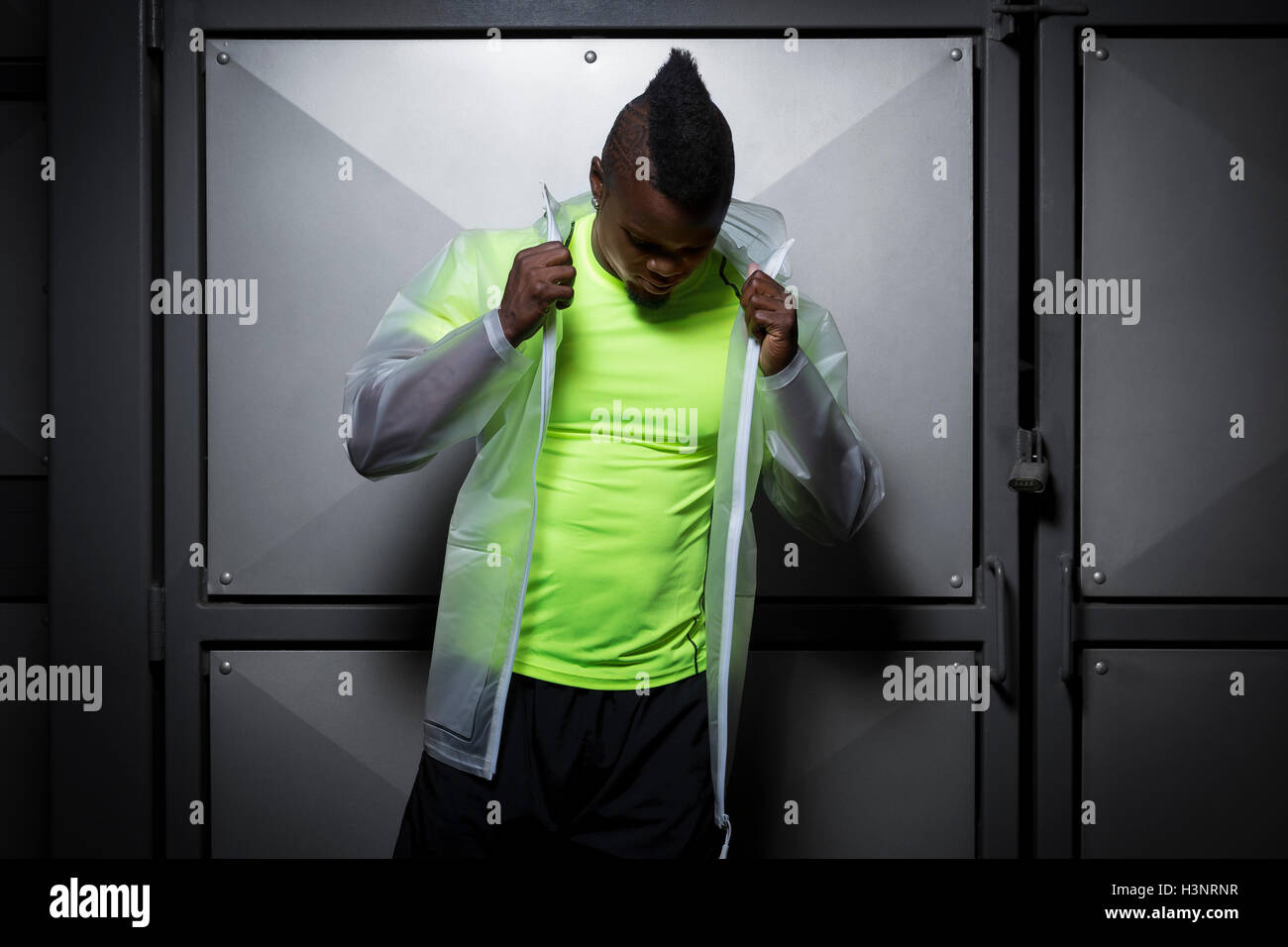 Junger Mann mit Mohawk, wasserdichte Jacke anziehen Stockfoto