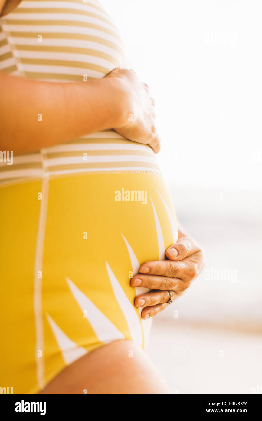 Mittleren Bereich der schwangeren Mitte Erwachsene Frau mit Bauch Makua Beach, Hawaii, USA Stockfoto
