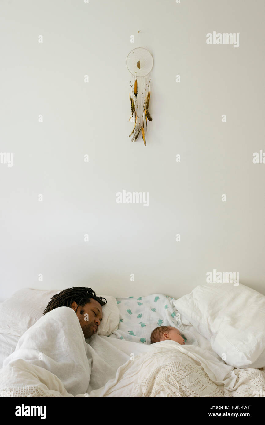 Vater und Baby jungen schlafen nebeneinander im Bett Stockfoto