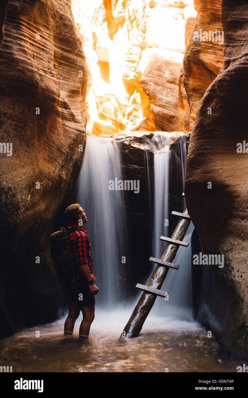Wanderer im Sandstein-Grotte mit Wasserfall, Kanarraville, Utah, USA Stockfoto