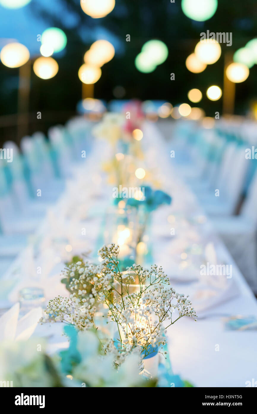 Romantisches Abendessen Setup, weiß und blau Thema mit Kerzenlicht, Laternen und Blumen geschmückt. Selektiven Fokus. Stockfoto