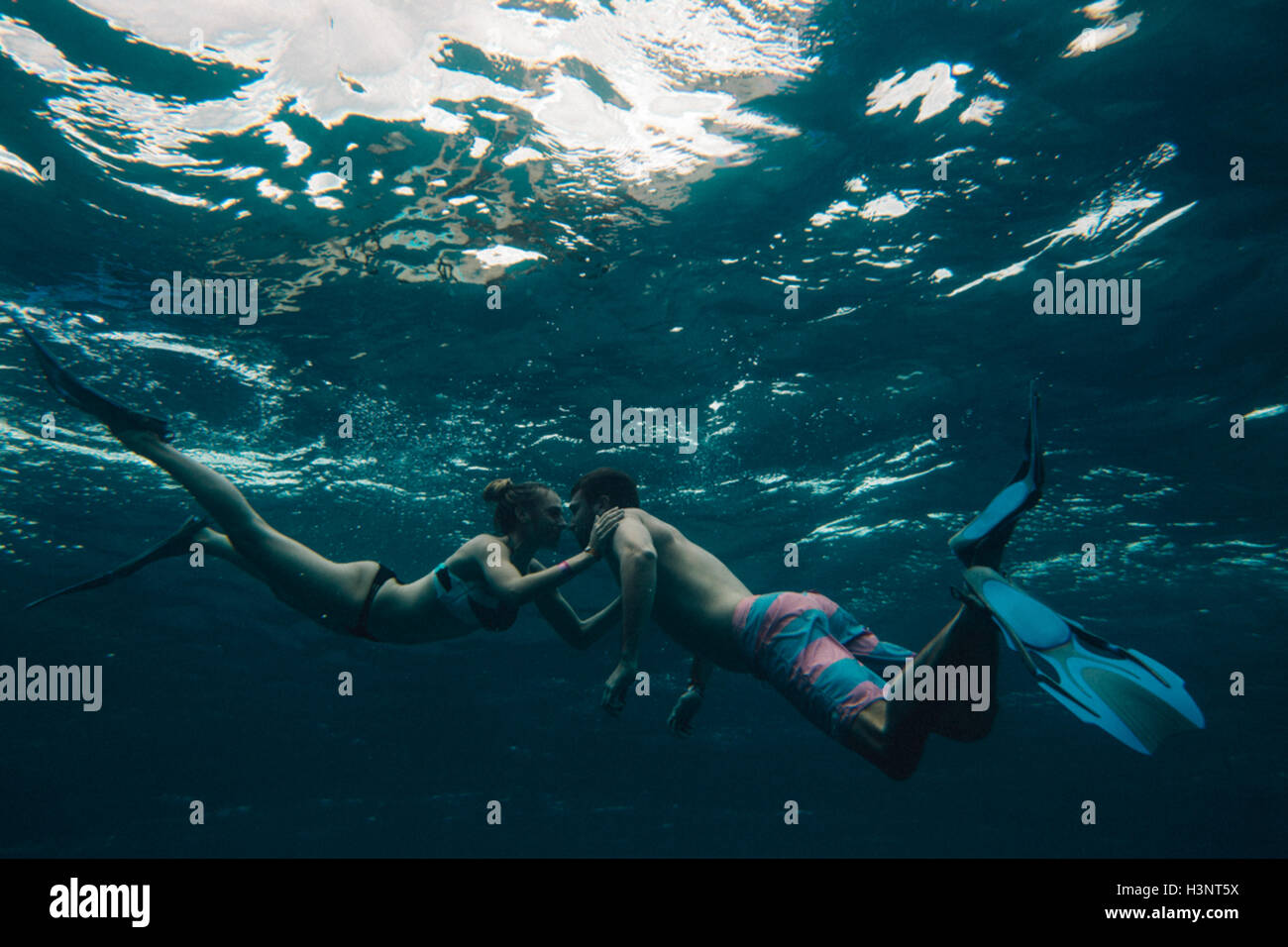 Unterwasser-Blick des Paares tragen flossen Stockfoto