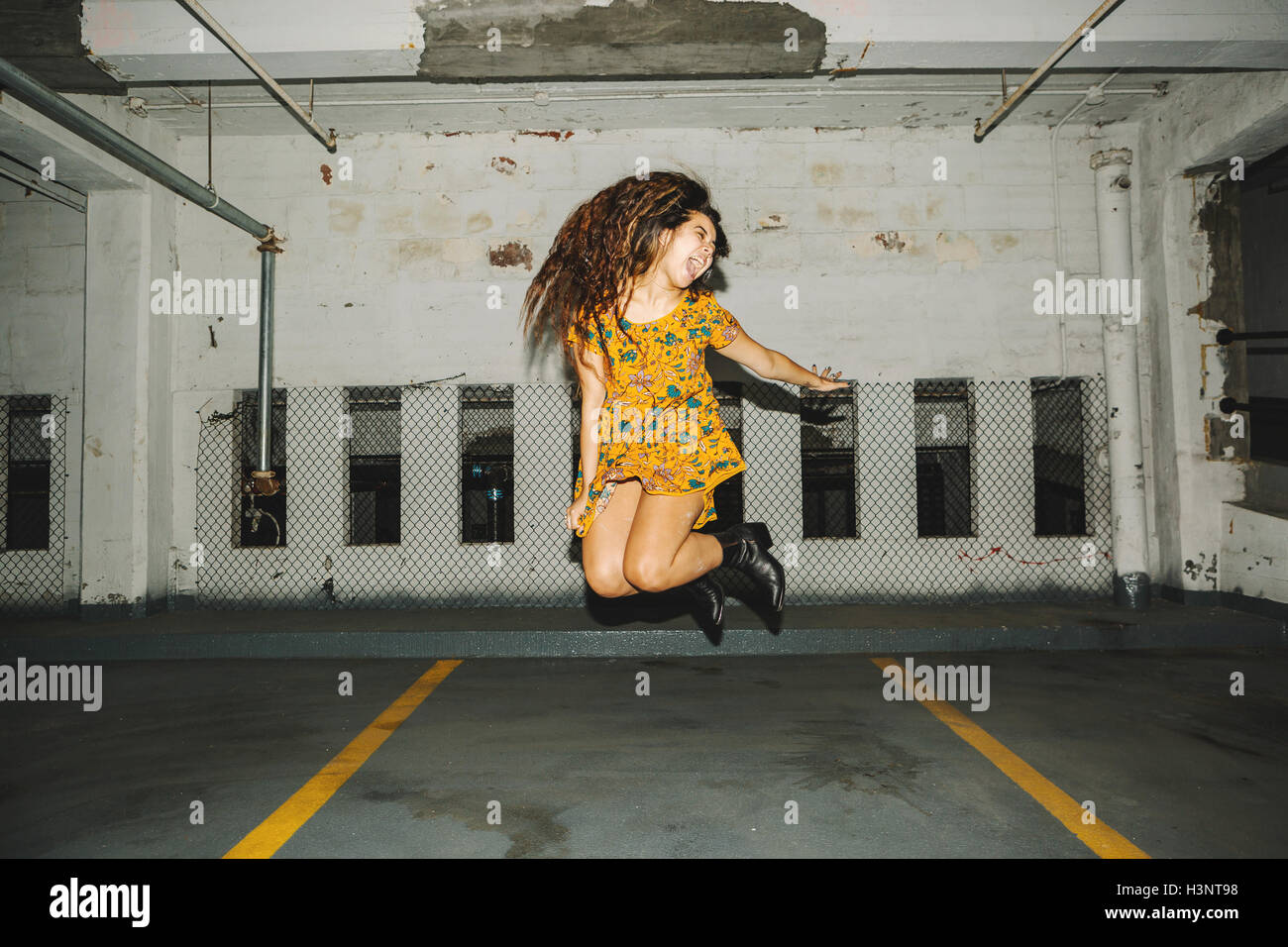 Junge Frau springen Luft im Parkhaus Stockfoto