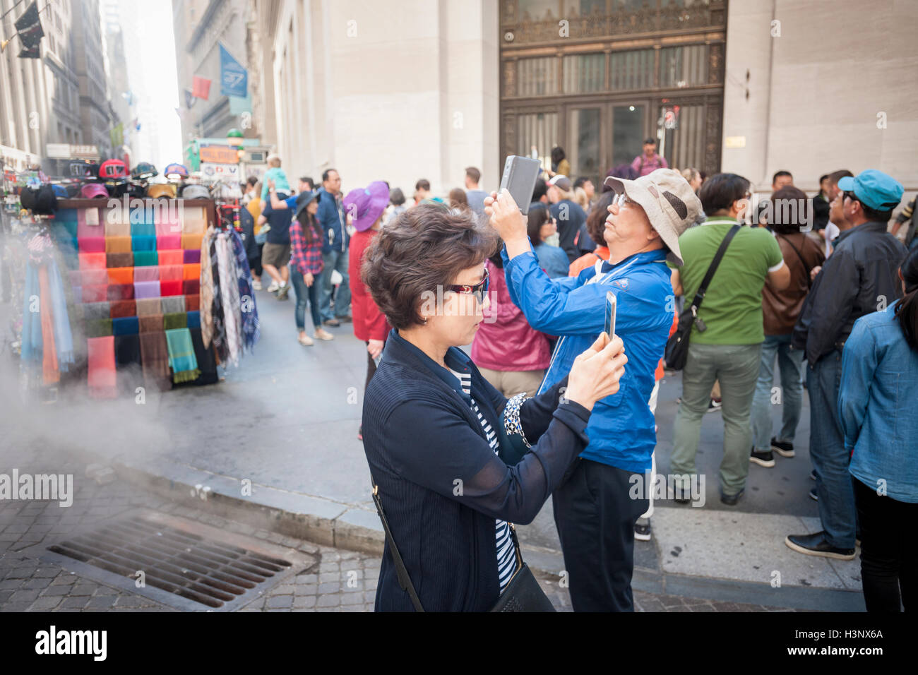 Asiatische Touristen an der Wall Street in New York am Freitag, 7. Oktober 2016 fotografieren mit ihren Smartphones. (© Richard B. Levine) Stockfoto