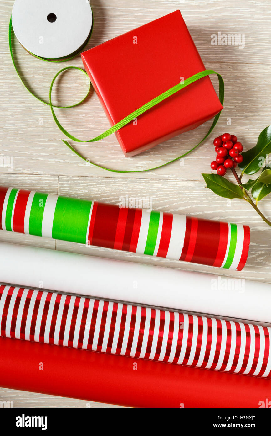 Rote und grüne Weihnachten Geschenkpapier Lieferungen Geschenkpapier, Geschenk-Box, präsentieren, Bänder und natürlichen botanischen Stechpalme Beeren Stockfoto