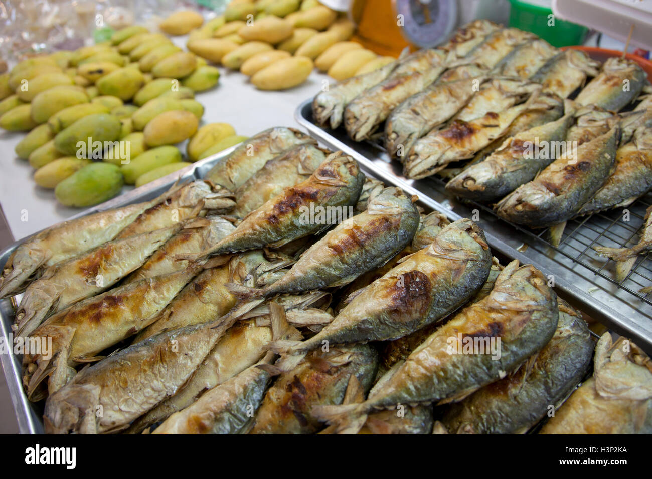 Gegrillte Fische und grüne Papaya zum Verkauf an oder Tor Gor Markt in Bangkok in Thailand. Stockfoto