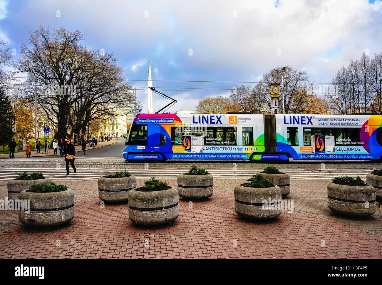 Riga, Lettland - 26. Dezember 2015: Straßenbahn und Menschen auf der Straße in der alten Stadt Riga, Hauptstadt Lettlands, an Weihnachten. Kein Schnee, kein Wind, nur Sonne. Selektiven Fokus Stockfoto