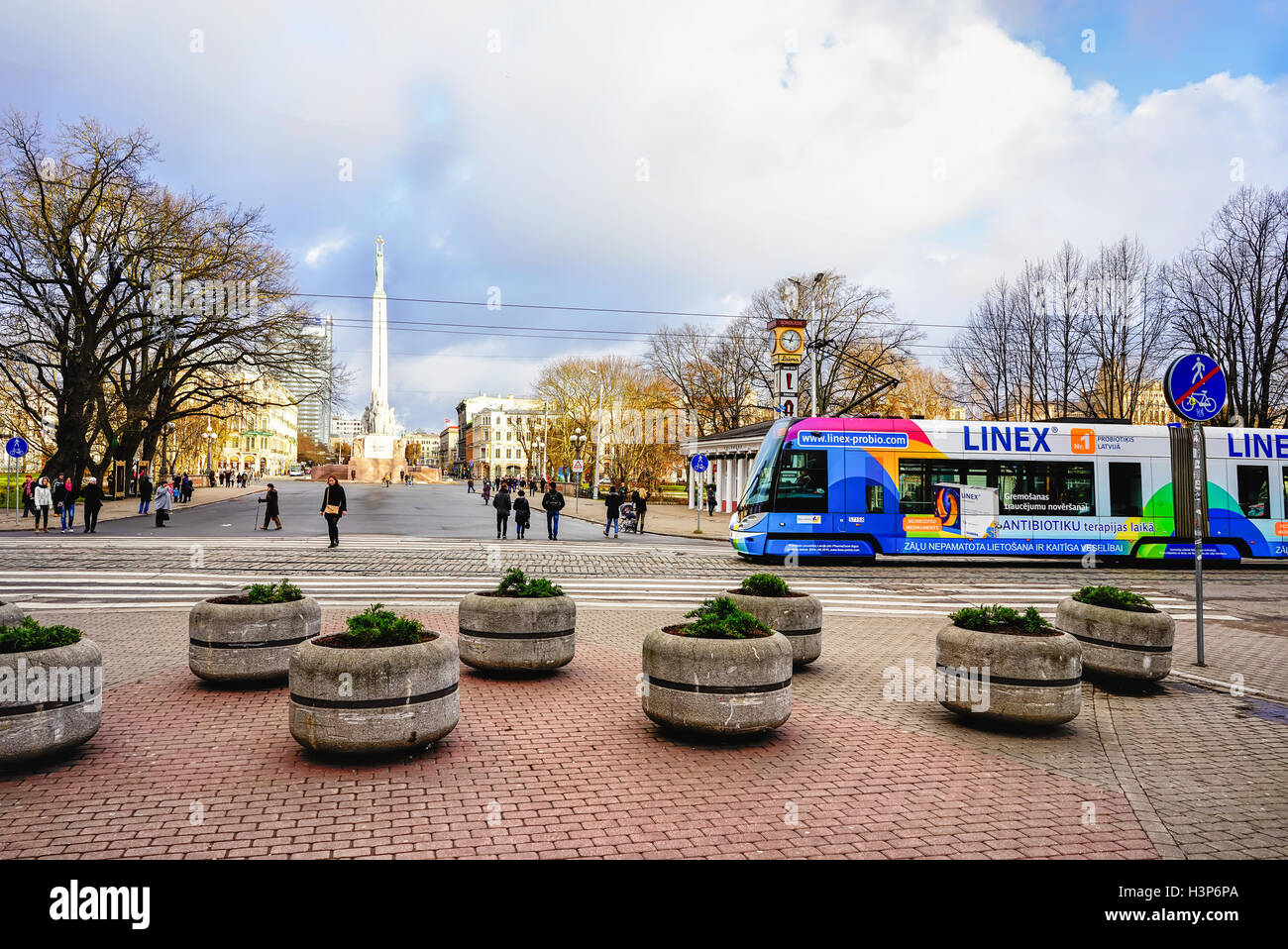 Riga, Lettland - 26. Dezember 2015: Straßenbahn und Menschen auf der Straße in der Altstadt von Riga, Hauptstadt Lettlands, an Weihnachten. Kein Schnee, kein Wind, nur Sonne. Stockfoto